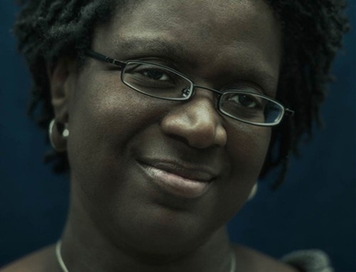 Retrato de una mujer negra y sonriente con gafas de lectura SKU: po-0005
